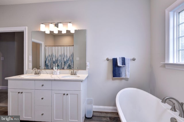 full bath with a wealth of natural light, baseboards, and a sink