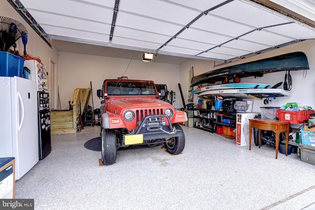 garage featuring a garage door opener and freestanding refrigerator