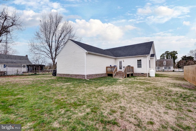 back of property featuring a wooden deck, fence, a lawn, and crawl space