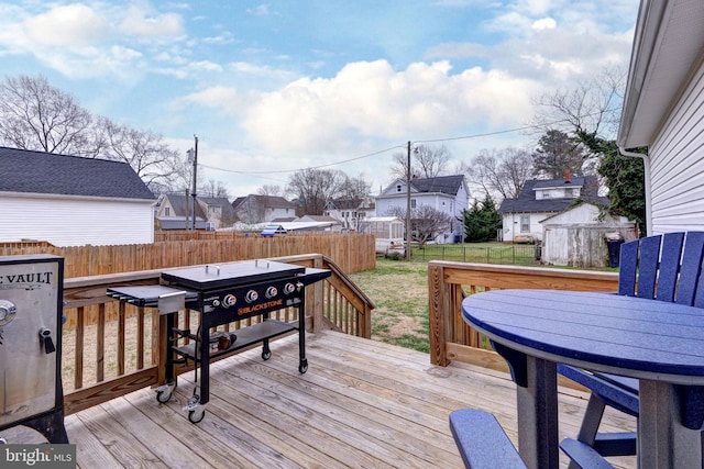 deck with a residential view, a yard, and fence