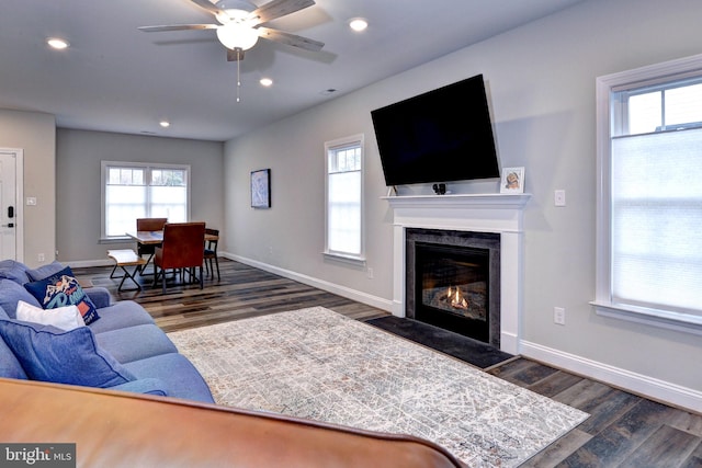 living room with recessed lighting, baseboards, dark wood-style floors, and a high end fireplace