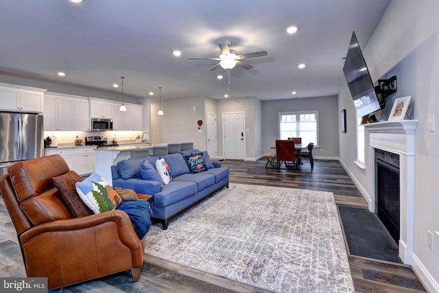 living area with dark wood-type flooring, recessed lighting, baseboards, and a high end fireplace