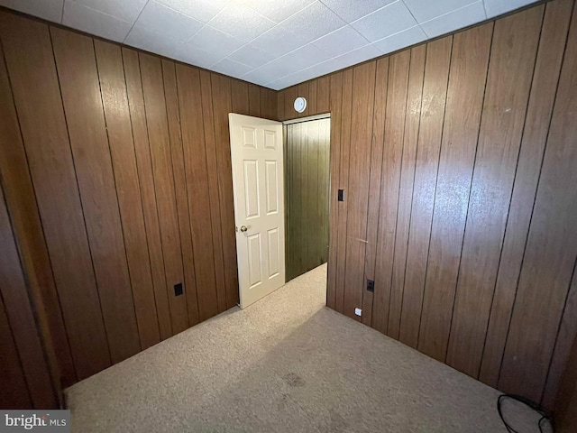 carpeted empty room with wooden walls