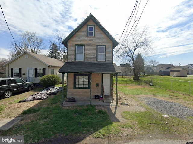 view of front facade with a front yard and fence