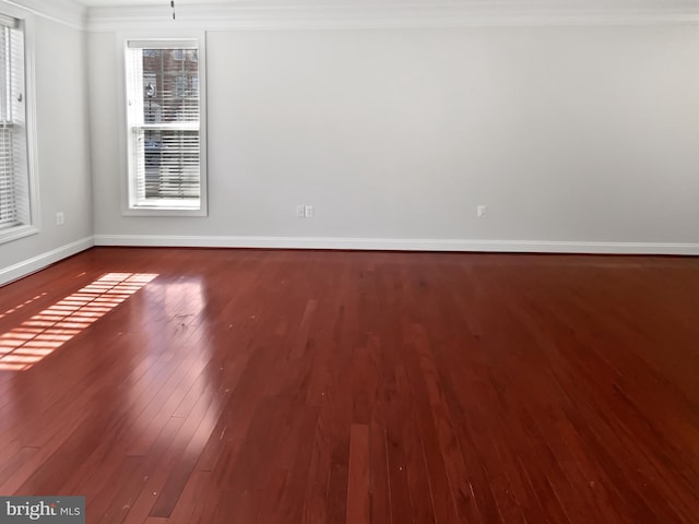 unfurnished room featuring crown molding, baseboards, and wood finished floors