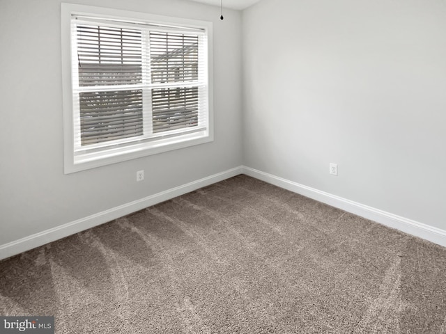 carpeted spare room featuring baseboards