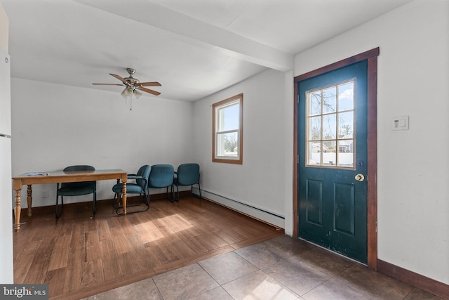 interior space with beam ceiling, a baseboard heating unit, a ceiling fan, wood finished floors, and baseboards