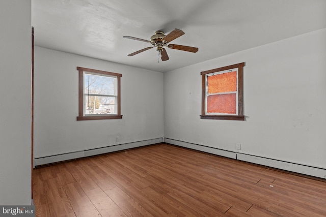 unfurnished room with a baseboard heating unit, wood finished floors, and a ceiling fan