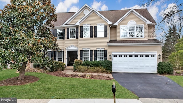 view of front of house with driveway, a front lawn, a garage, and a shingled roof