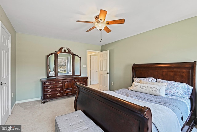 bedroom featuring light colored carpet, baseboards, and ceiling fan