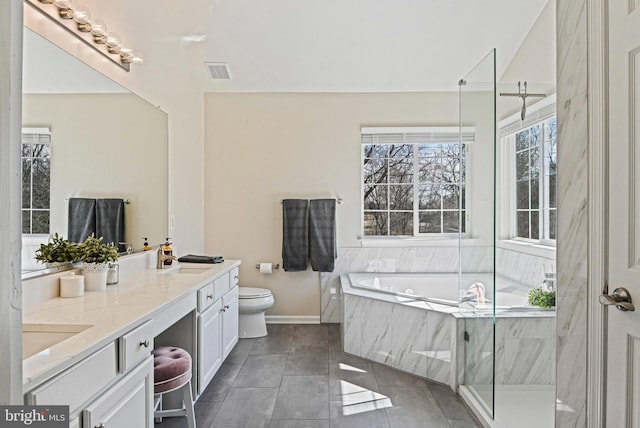 full bathroom with double vanity, a sink, tile patterned flooring, a garden tub, and toilet