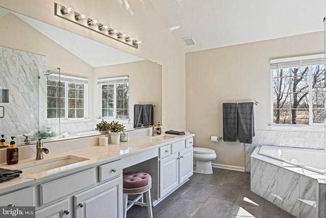 bathroom featuring double vanity, a sink, vaulted ceiling, a shower stall, and a bath