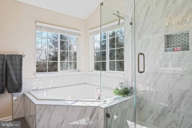 bathroom with a jetted tub and a marble finish shower