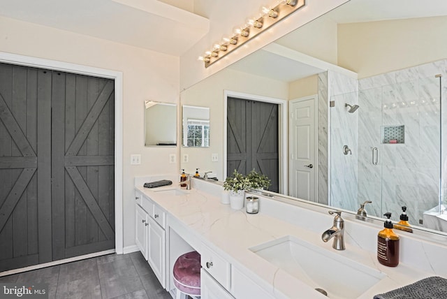 full bath with double vanity, a shower stall, and a sink