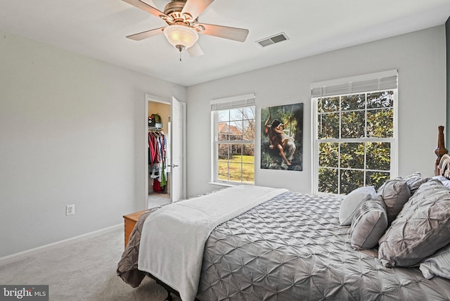 carpeted bedroom with visible vents, baseboards, ceiling fan, and a spacious closet