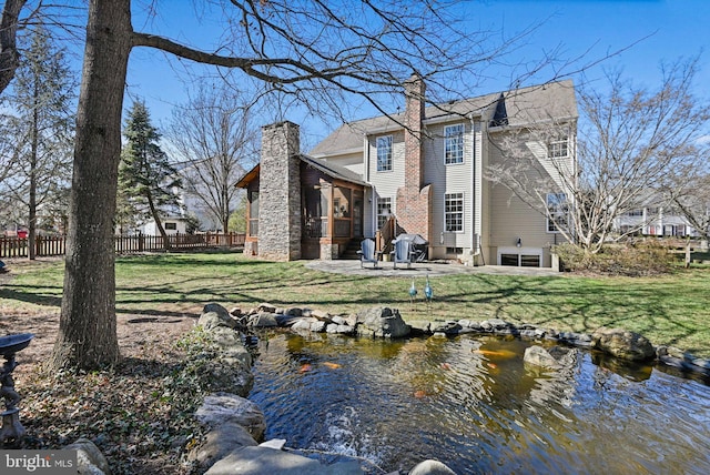 back of property with a patio, fence, a lawn, and a chimney