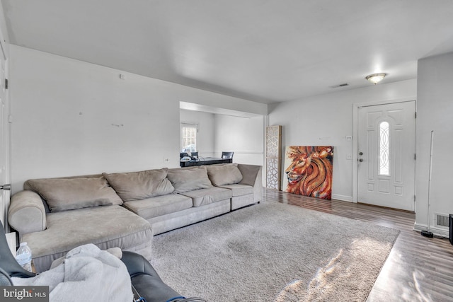 living area with visible vents, baseboards, and wood finished floors