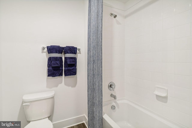 full bath featuring  shower combination, toilet, and baseboards