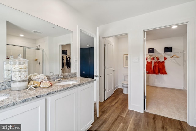 bathroom with double vanity, a sink, visible vents, and a shower stall