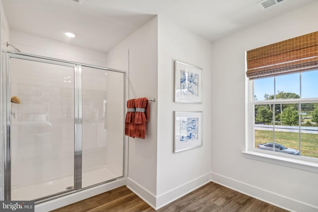 full bathroom with a shower stall, baseboards, and wood finished floors