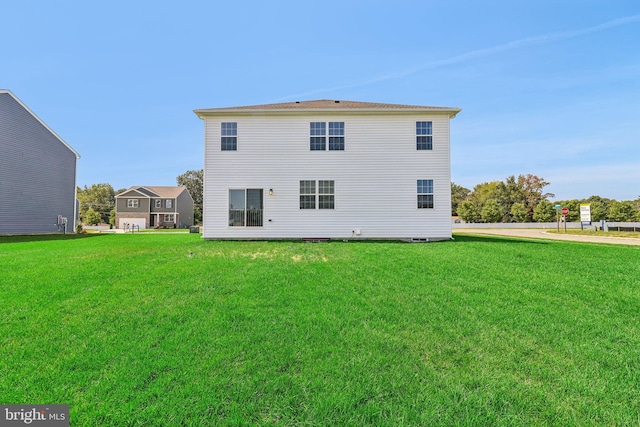 rear view of house featuring a lawn