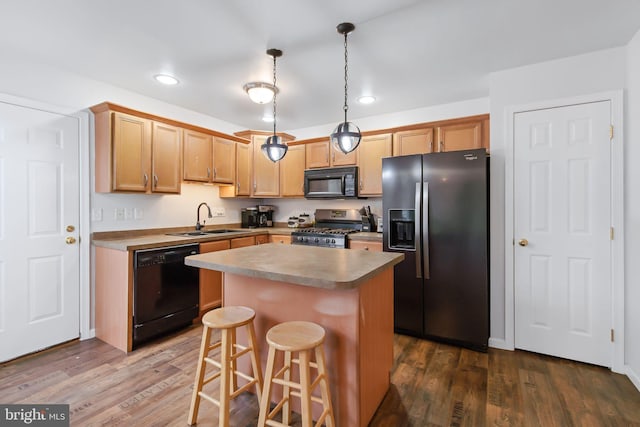 kitchen featuring dark wood-type flooring, a sink, black appliances, and a kitchen island