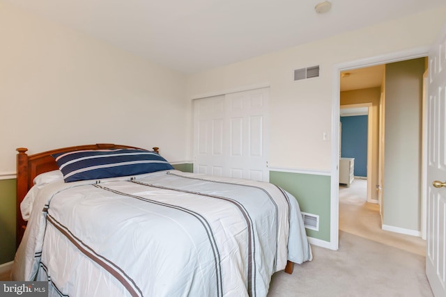 bedroom featuring light carpet, a closet, visible vents, and baseboards