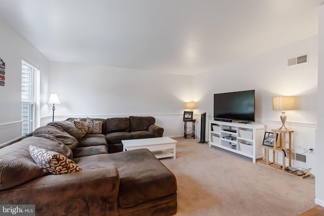 carpeted living room with wainscoting and visible vents