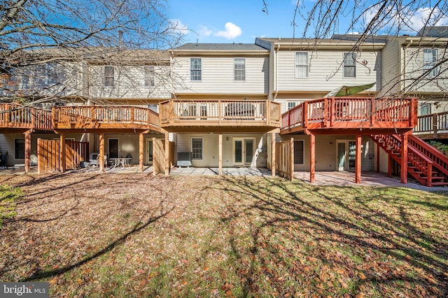 back of property featuring central AC, a deck, a patio area, a yard, and stairway