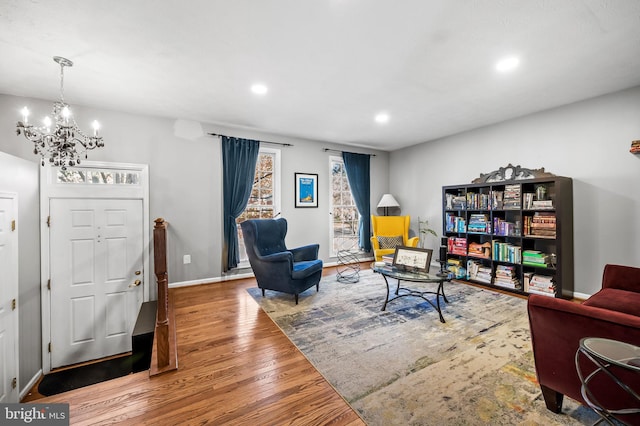 living area featuring recessed lighting, baseboards, wood finished floors, and a chandelier