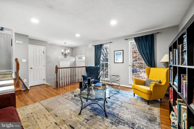 sitting room with recessed lighting, baseboards, wood finished floors, and an inviting chandelier