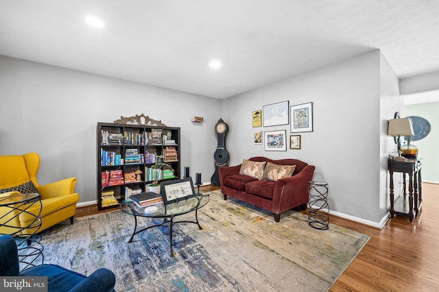 living area with baseboards, recessed lighting, and wood finished floors