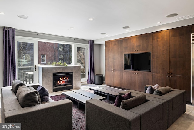 living area with recessed lighting, light tile patterned flooring, visible vents, and a tiled fireplace