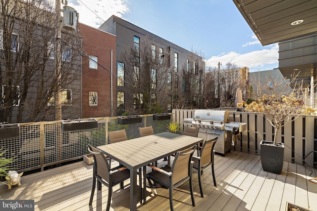 deck with outdoor dining area and a grill