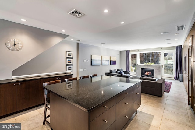 kitchen featuring a center island, a breakfast bar area, recessed lighting, visible vents, and a high end fireplace