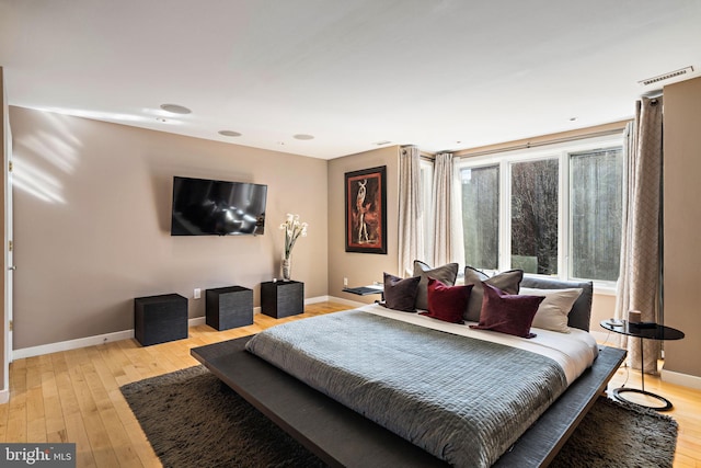 bedroom featuring light wood finished floors and baseboards