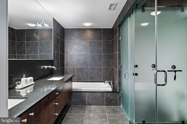 bathroom with tile patterned flooring, visible vents, a sink, and a bath