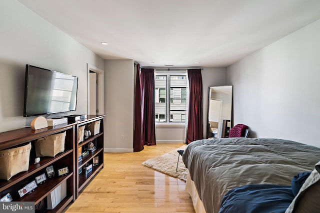 bedroom with light wood finished floors and baseboards