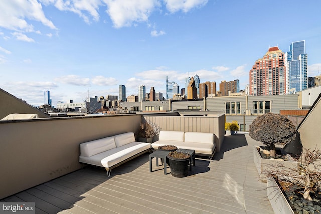 wooden deck with a view of city and outdoor lounge area