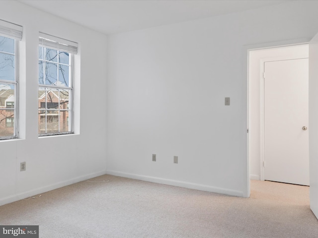 spare room featuring baseboards and carpet floors