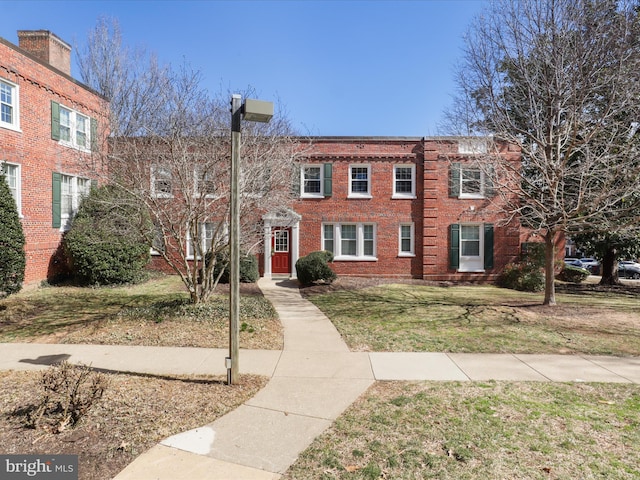 multi unit property featuring brick siding and a front yard