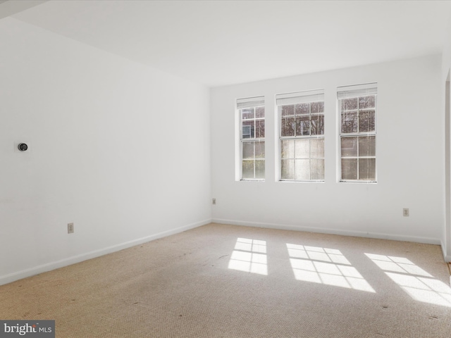 empty room with baseboards and carpet