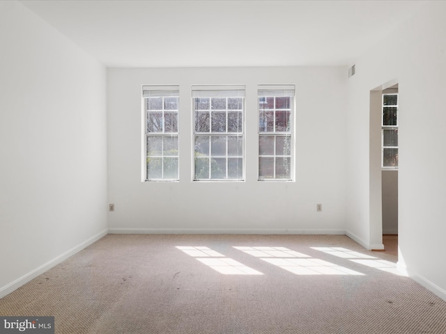 carpeted spare room featuring baseboards