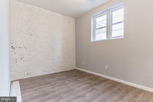 unfurnished room with wood finished floors and baseboards