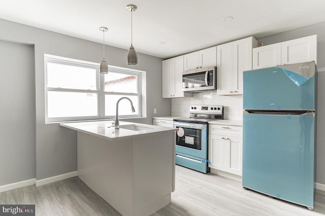 kitchen featuring a sink, white cabinets, appliances with stainless steel finishes, backsplash, and light wood finished floors