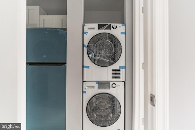 laundry room featuring stacked washer / dryer and laundry area