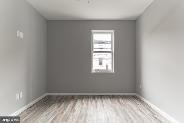 empty room with baseboards and wood finished floors