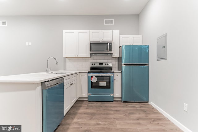 kitchen with electric panel, visible vents, a sink, stainless steel appliances, and backsplash