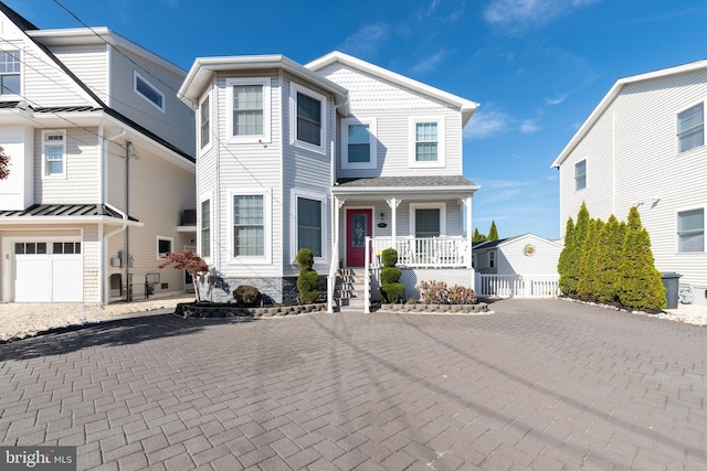 view of front of home with a standing seam roof, a porch, and decorative driveway