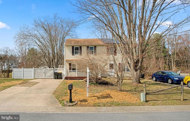 view of front of home with driveway, fence, and a gate